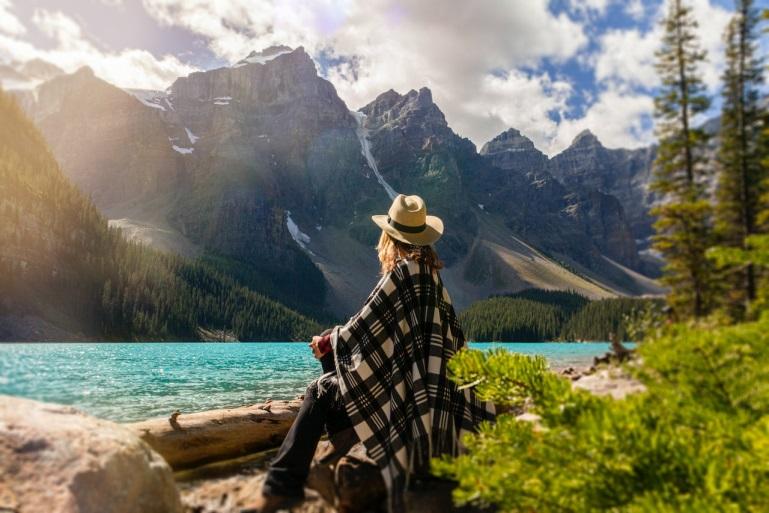woman sitting on a rock beside a lake